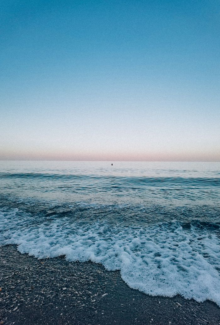 Tranquil beach scene in Odessa, Ukraine, capturing the gentle waves at sunrise.