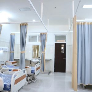 Clean and modern hospital ward with beds and privacy curtains in Surabaya, Indonesia.